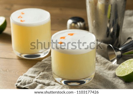 Homemade Pisco Sour Cocktail with Lime and Bitters Royalty-Free Stock Photo #1103177426