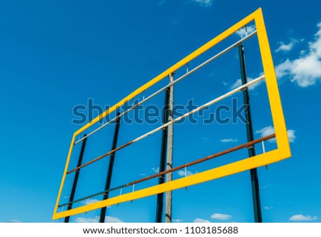 Blank billboard with yellow frame against a blue sky background.