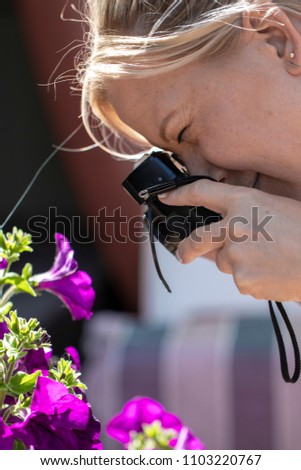 A young woman taking pictures with her camera