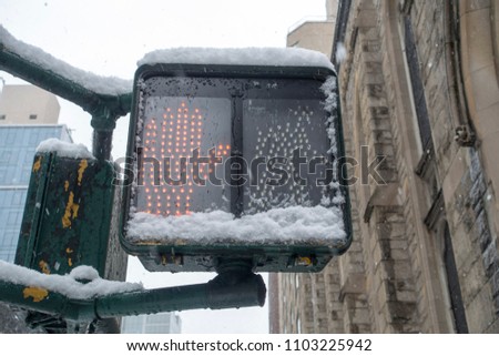 stop walking lighted new york city street sign with spot hand icon and snow cover