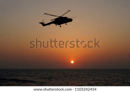Helicopter flying with a sunset in the background