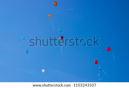 Many bright baloons in the light blue sky.
balloons skies fly high