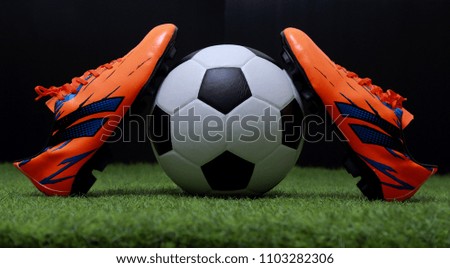 close up legs and feet of soccer player or football player walk on green grass ready to play match on black background.