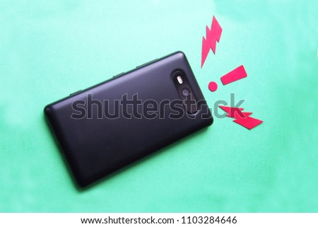 Black smartphone on a turquoise background, arrow marks and exclamation, active gadget of modern technology in action