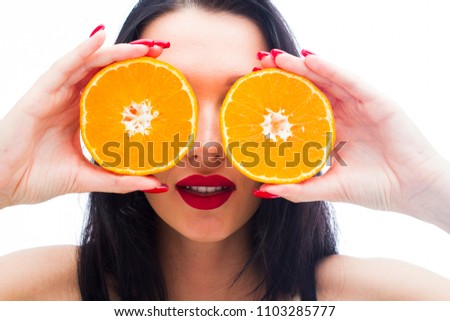 Girl holding oranges near the eyes