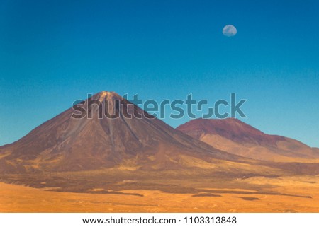 An amazing view of the moon rising up over Licancabur Volcano at Atacama Desert, Chile