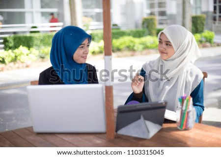 Two young and dynamic Muslim businesswoman are having a business strategy meeting to discuss their business.