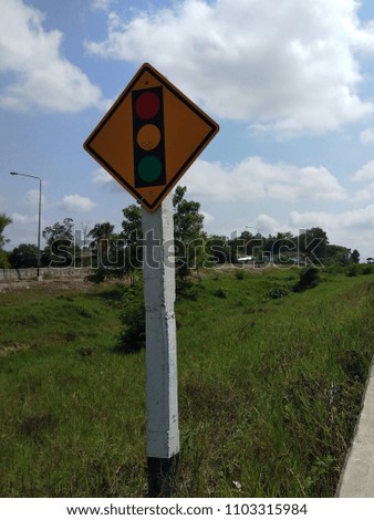 traffic sign on the white pole beside the highway show traffic lights ahead. 