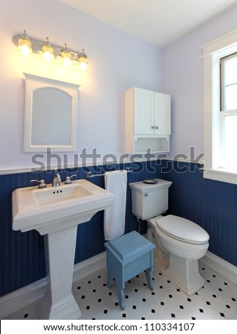 Bathroom with sink and toilet with blue walls and tile floor.