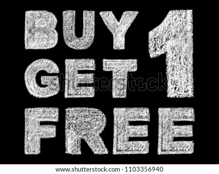 handwritten white bold chalk lettering buy 1 get 1 free text on black background, hand-drawn chalk phrase, back to school concept, stock photo image