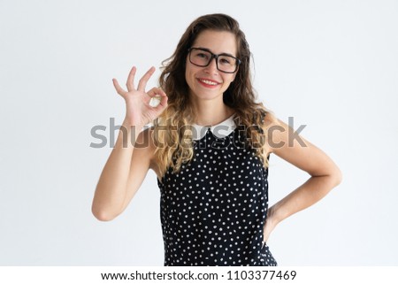 Smiling young beautiful woman showing OK sign and looking at camera. Recommendation concept. Isolated front view on white background.