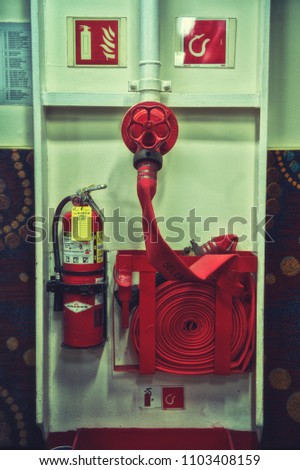 Fire extinguisher and fire hose reel on wall
