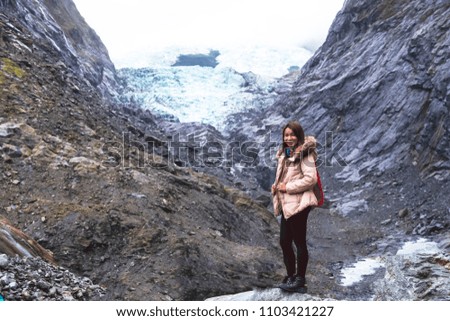 Tourist Asia Woman at Franz Josef Glacier New Zealand in rain winter
