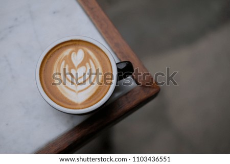 A cup of coffee latte with beautiful latte art on marble table.