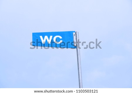 WC sign for public toilet or restroom against sky