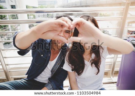 Portrait lovely couple. Handsome boyfriend and beautiful girlfriend is making symbol of love by using their hand and fingers for making a shape of heart. They have honeymoon and special time together