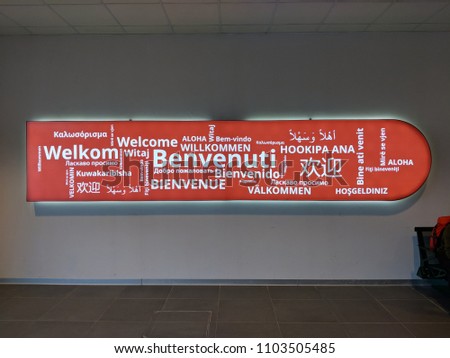 Welcome sign in Bologna Airport, in different languages (translation: welcome all).