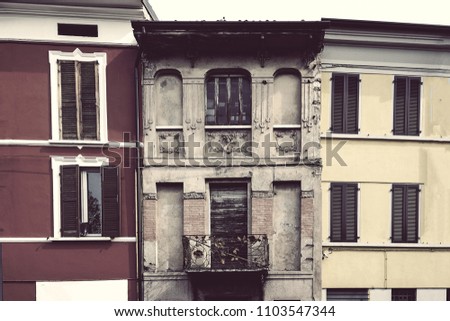 Old house between new. Tall aged building with uneven edges and worn facade stuck by modern houses. Cities and urban life concept photo