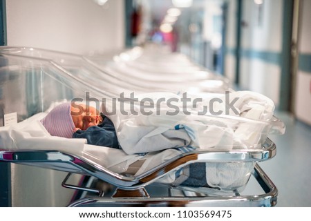Newborn baby in first of many small hospital beds  Royalty-Free Stock Photo #1103569475