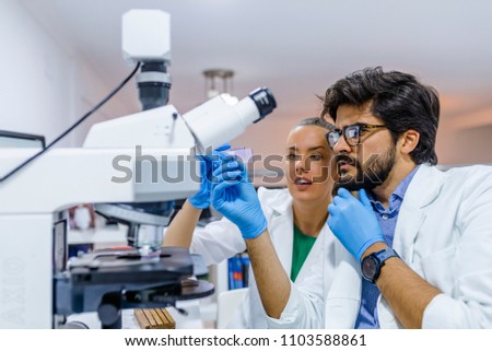 Group of Genetics engineering students working together in lab. Laboratory teamwork by college student indoors. Working in lab
