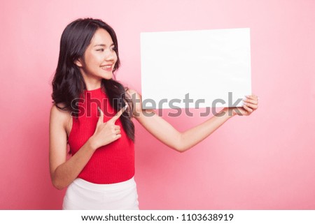 Young Asian woman point to  blank sign on pink background