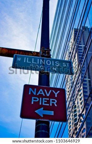 Chicago street signs for Illinois Street and Navy Pier, directing with arrow.