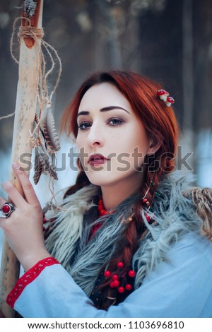 Beautiful girl with long braids in a winter forest. A witch from a fairy tale. fantasy Photo