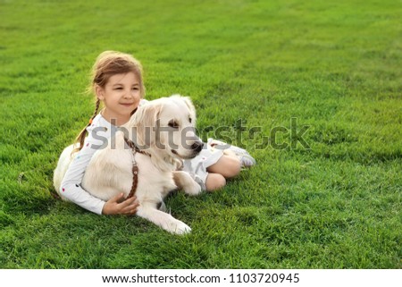 Cute little child with his pet on green grass