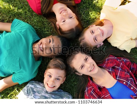 Group of children lying on grass, top view. Summer camp