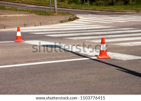 Work on road. Construction cones. Traffic cone, with white and orange stripes on asphalt. Street and traffic signs for signaling. Road maintenance, under construction sign and traffic cones on road.