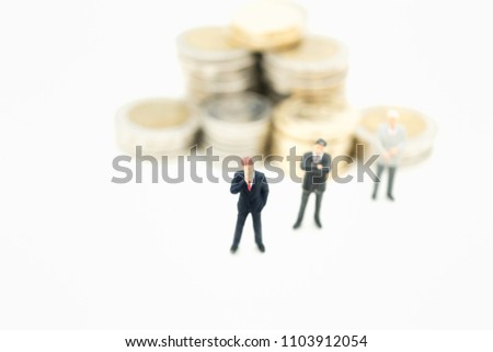 Miniature people: Group of business team standing with stack of coins using as background money, business growth up concept.