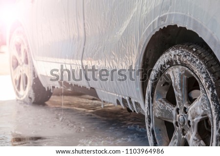 car wash self-service; Manual car wash. Washing luxury vehicle with white foamy detergent. Automobile  cleaning self service Royalty-Free Stock Photo #1103964986