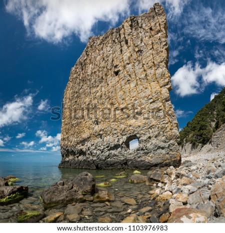 Vertical cliff with hole inside named Sail cliff (Skala Parus) on the coast of Black Sea. Gelendzhik district, Krasnodar region, Russia. Royalty-Free Stock Photo #1103976983