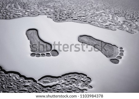 dry traces of human feet in a pool of water.