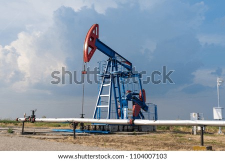 Working oil rig in a cornfield