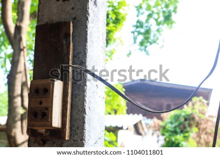 Asian old electric plug with multiple socket outside on wooden pole.