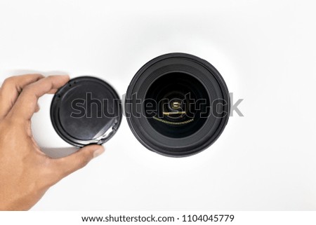 hand removing lens cap from the lens