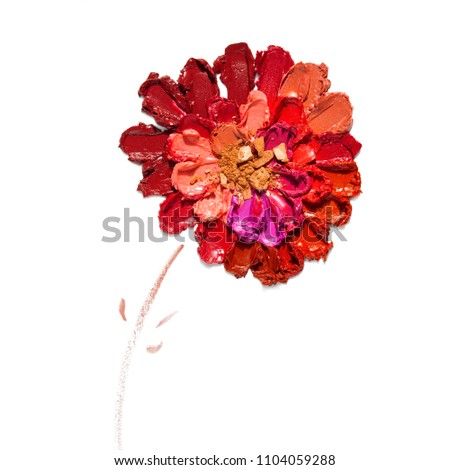 Creative concept photo of cosmetics swatches beauty products lipstick arranged as a flower on white background.