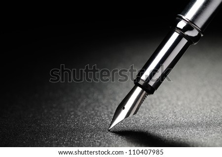Old fountain pen on a black textured background Royalty-Free Stock Photo #110407985