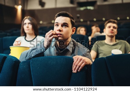 Scared man watching movie in cinema