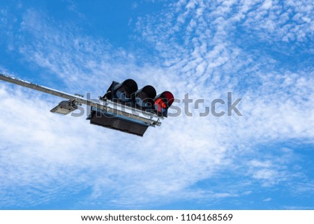 Stop signal for traffic light on the road with blue sky and clouds