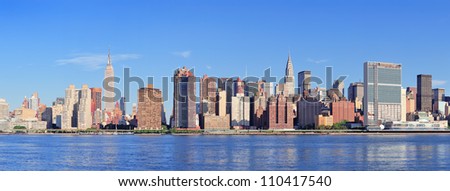 Manhattan midtown skyline panorama over East River with urban skyscrapers and blue sky in New York City