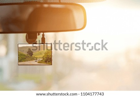 Car on the road,Close up car on highway at sunset, with video recorder next to a rear view mirror,video recorder driving a car on highway,car video recorder,Full HD camera recorder for vehicle.