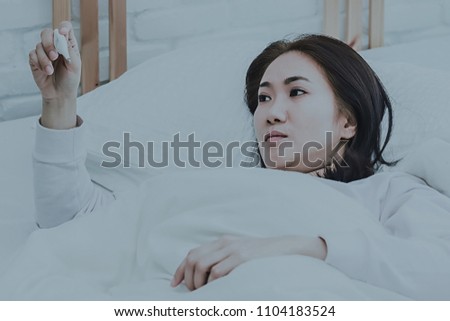 Asian woman use a thermometer to detect fever in bedroom.color tone