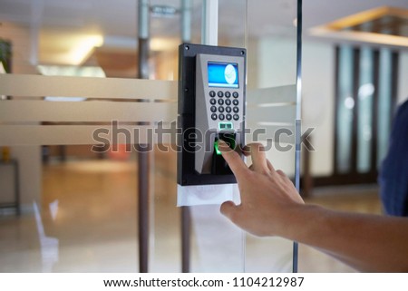 Yong man press down the finger on fingerprints scan machine to access the door security systems. Selective focused Royalty-Free Stock Photo #1104212987