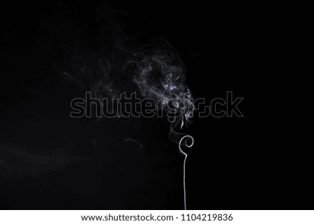 Vertical smoky swirl of burning aromastick