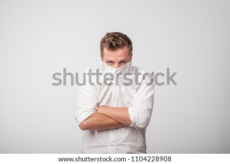 Shy caucasian man hiding behind his white shirt. Concept of being shy Royalty-Free Stock Photo #1104228908