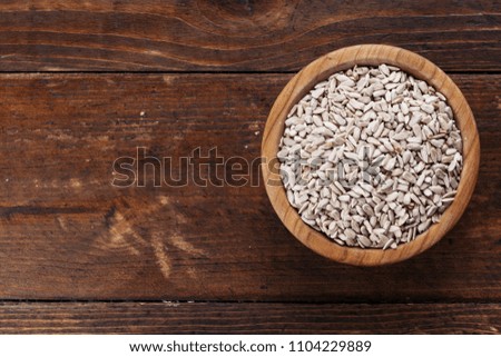 Peeled sunflower seeds on a wooden background in a plate. place for text
