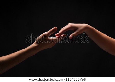 Male holding female hands on black isolated background. Love, relations, support, together forever concept. Copy space, cutout, low key