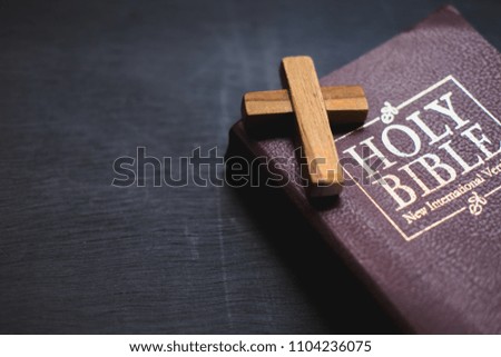 A wooden Christian cross on holy bible , The way to God through prayer.